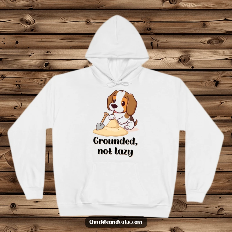 Funny Basset Hound hoodie depicting a charming Basset Hound intently building a sandcastle with a small shovel, perfect for beach lovers.