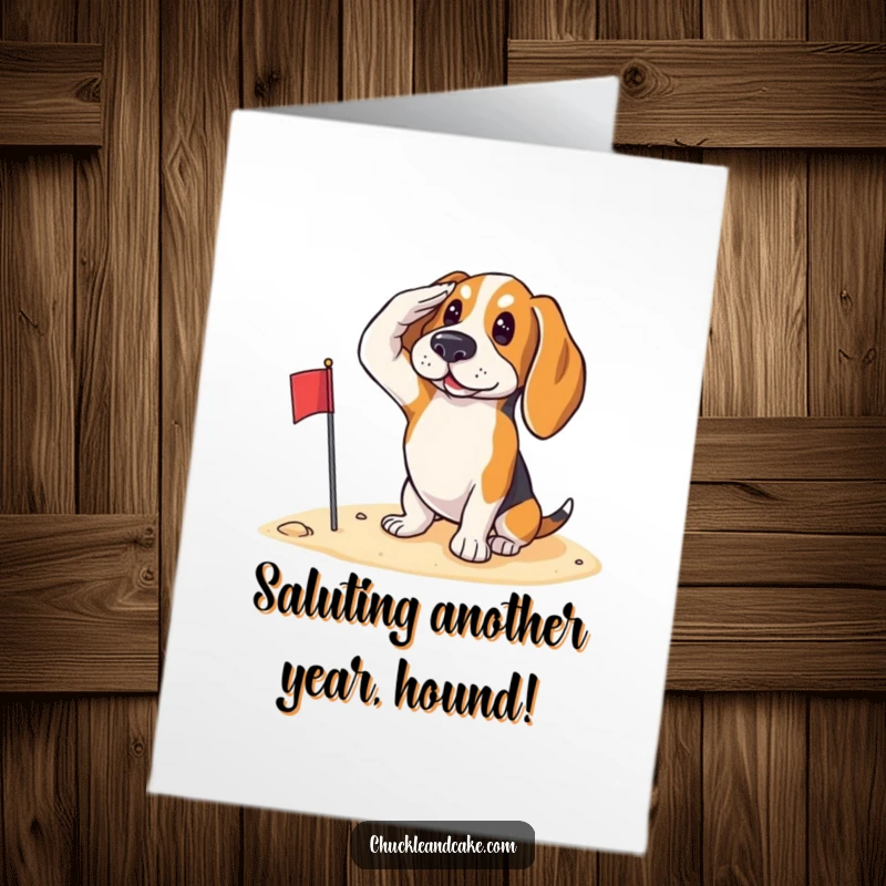 Funny Free Printable Birthday Card: A Basset Hound proudly salutes with a small flag on a sandy beach.